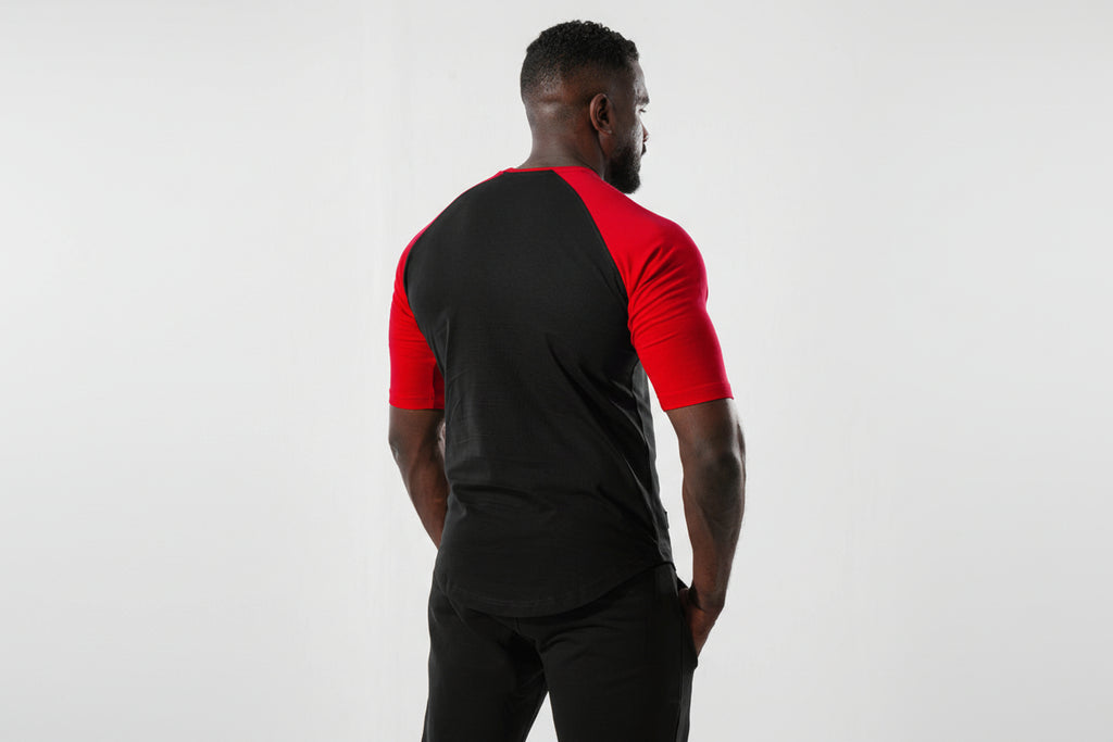 Man wearing a black and red athletic shirt on a white background

