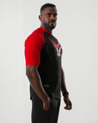 Man wearing a black and red sports outfit on a white background

