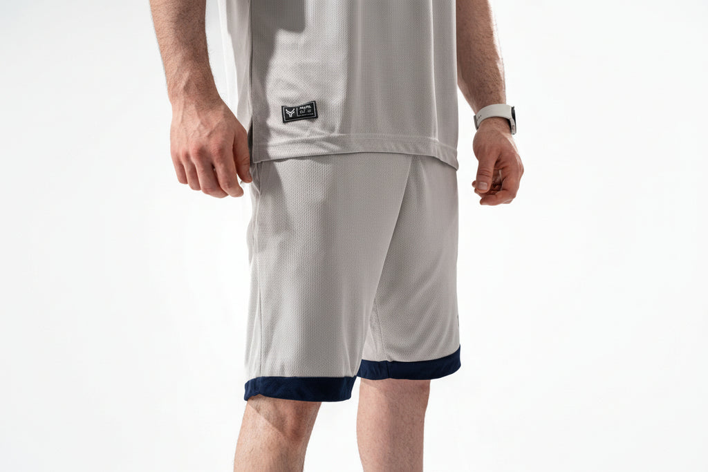 Person wearing a white sports outfit with a logo on a white background