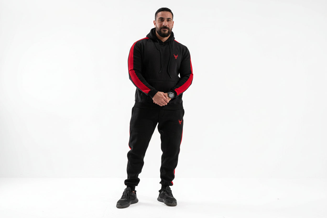Man wearing a black and red tracksuit with a logo on a white background

