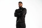 Man wearing a black jacket with a logo on a white background