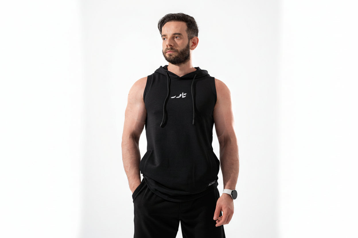 Man wearing a black sleeveless hoodie with a logo on a white background

