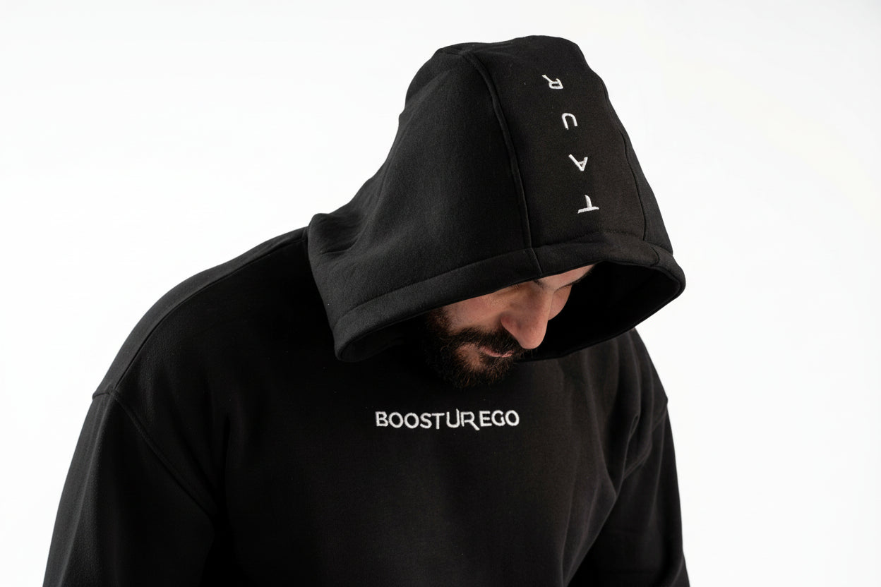 Person wearing a black hoodie with 'BOOSTUR EGO' branding on a white background


