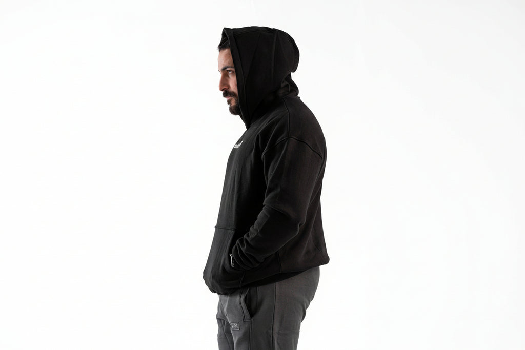 Person wearing a black hoodie on a white background

