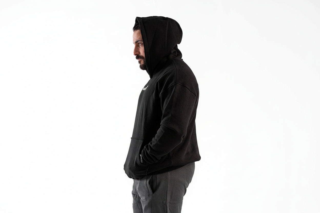 Person wearing a black hoodie on a white background

