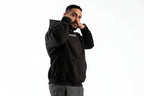Man wearing a black hoodie with text on a white background

