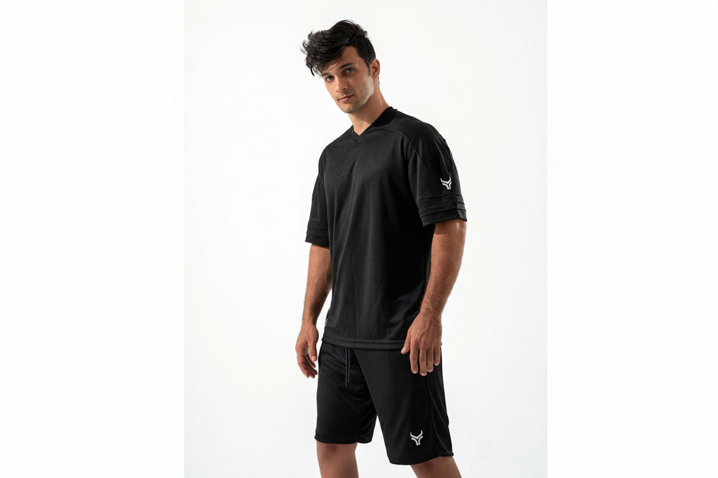 Man wearing a black athletic outfit with a logo on a white background