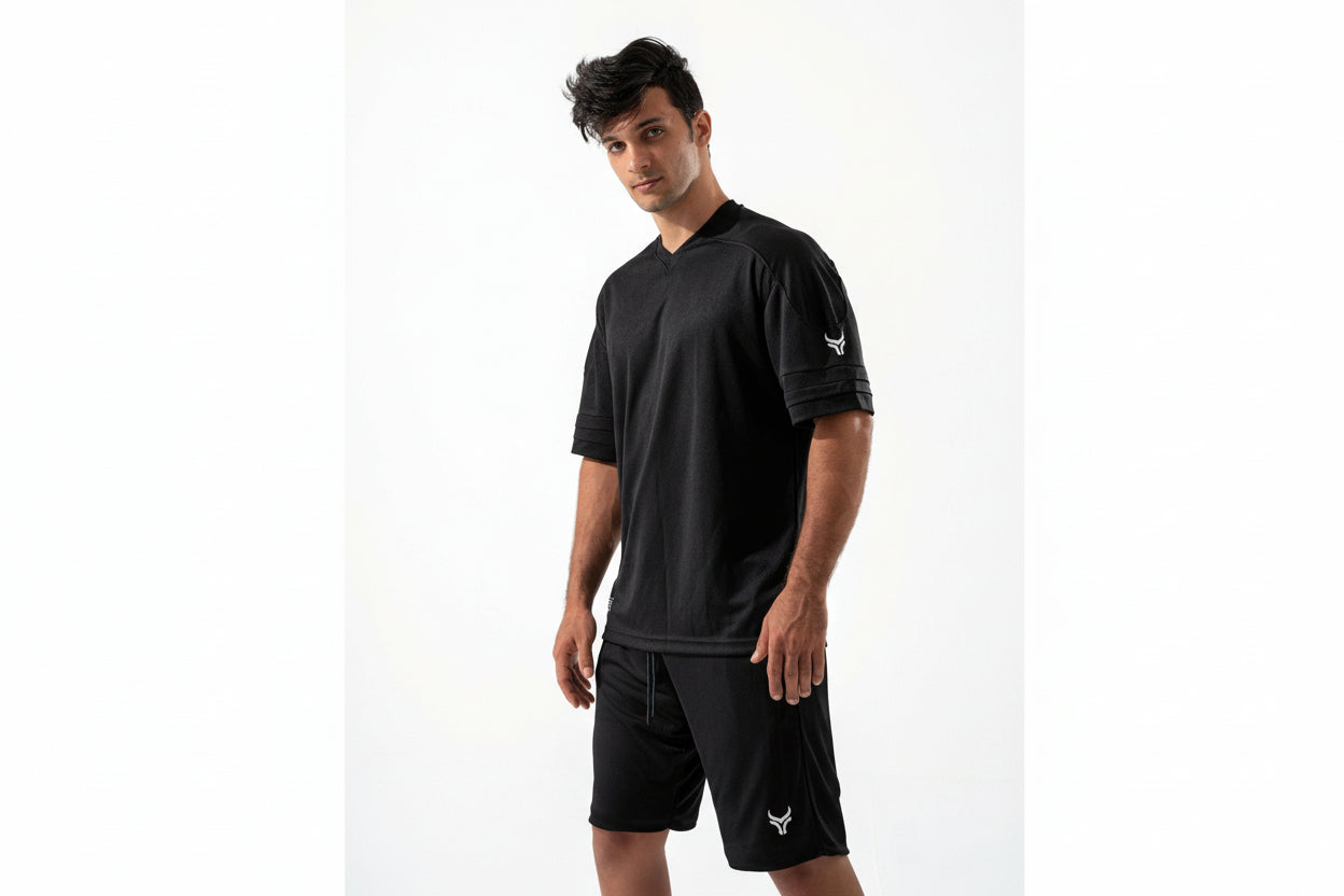 Man wearing a black athletic outfit with a logo on a white background