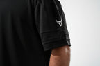 Black athletic shirt with a logo on the sleeve against a white background

