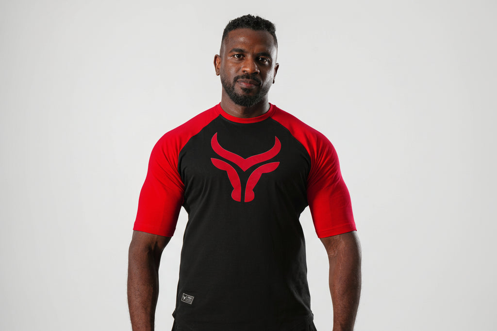 Man wearing a black and red athletic outfit with a logo on a white background

