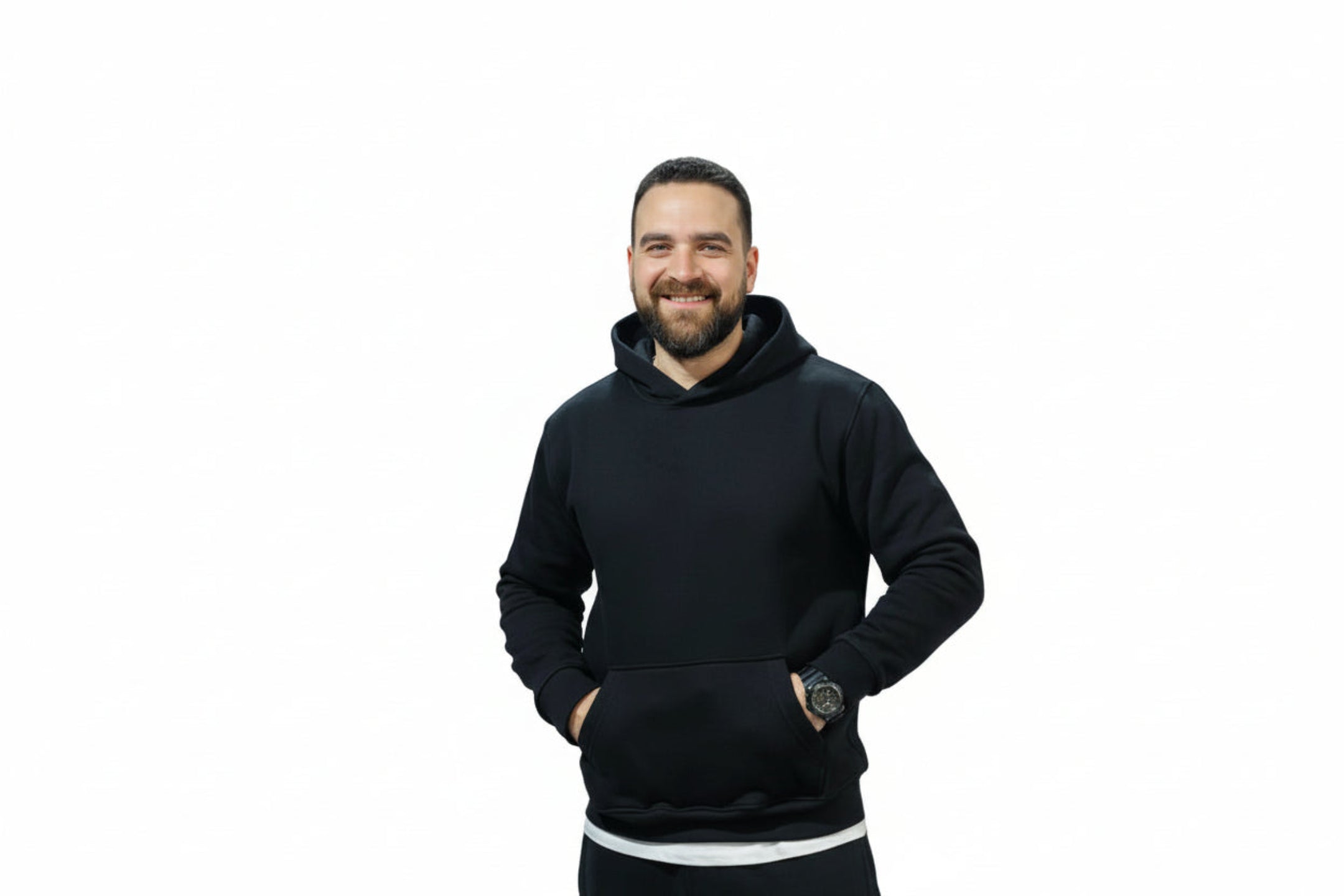 Man wearing a black hoodie standing in an indoor sports facility.

