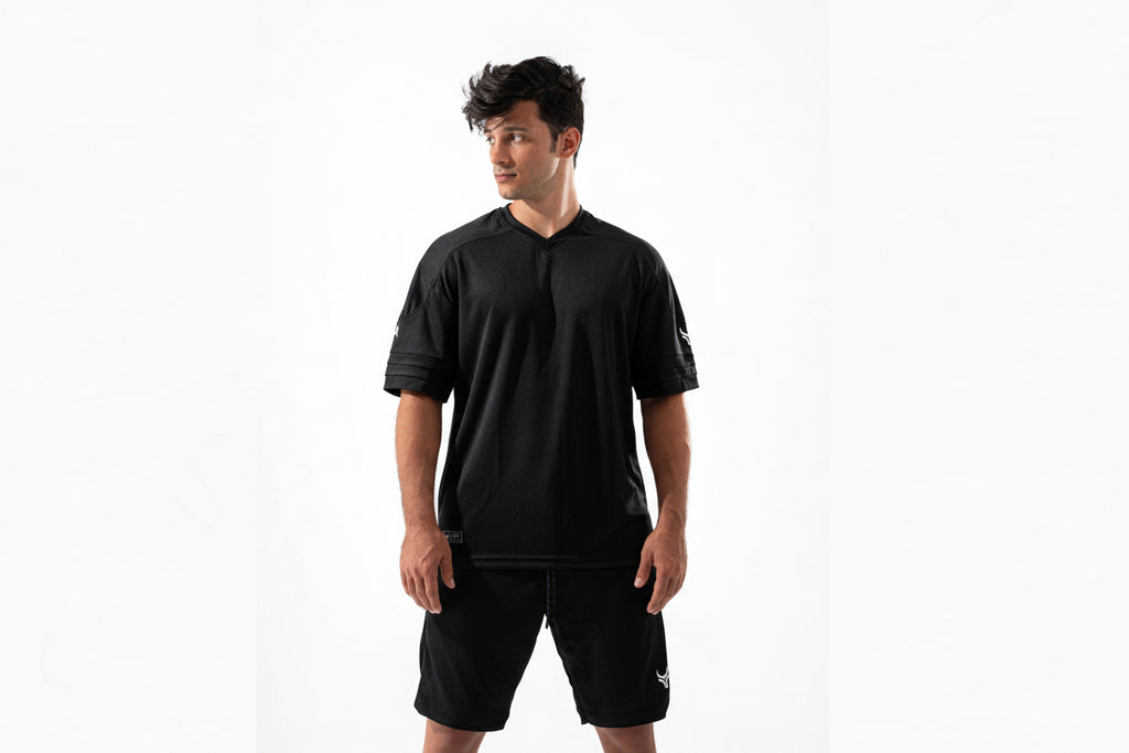 Man wearing a black sports outfit with a logo on a white background