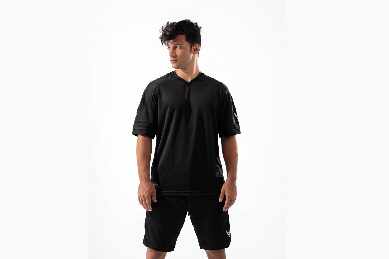 Man wearing a black sports outfit with a logo on a white background