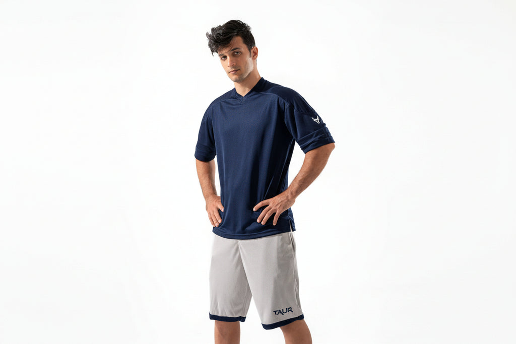 Man wearing a navy blue shirt and white shorts on a white background

