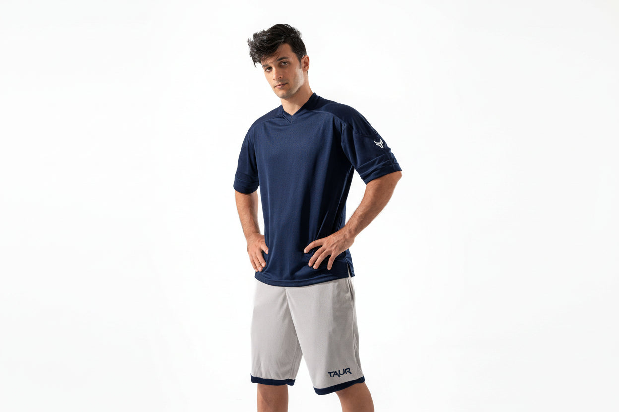 Man wearing a navy blue shirt and white shorts on a white background

