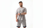 Man wearing a gray athletic outfit with a white background

