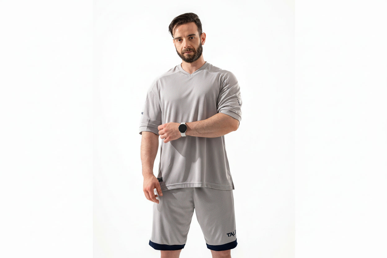 Man wearing a gray athletic outfit with a white background

