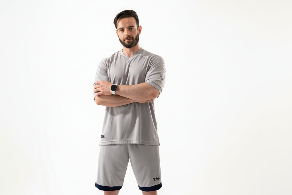 Man wearing a gray athletic outfit with a white background