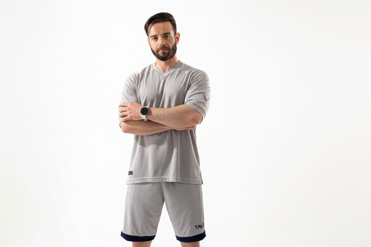 Man wearing a gray athletic outfit with a white background
