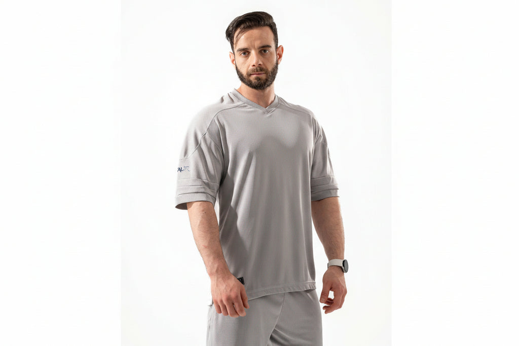 Man wearing a gray athletic outfit with a visible brand logo on a white background