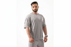 Man wearing a gray athletic outfit with a visible brand logo on a white background