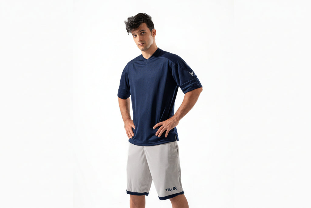 Man wearing a navy blue shirt and white shorts on a white background