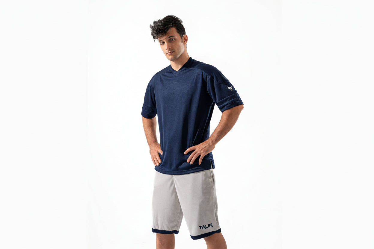 Man wearing a navy blue shirt and white shorts on a white background