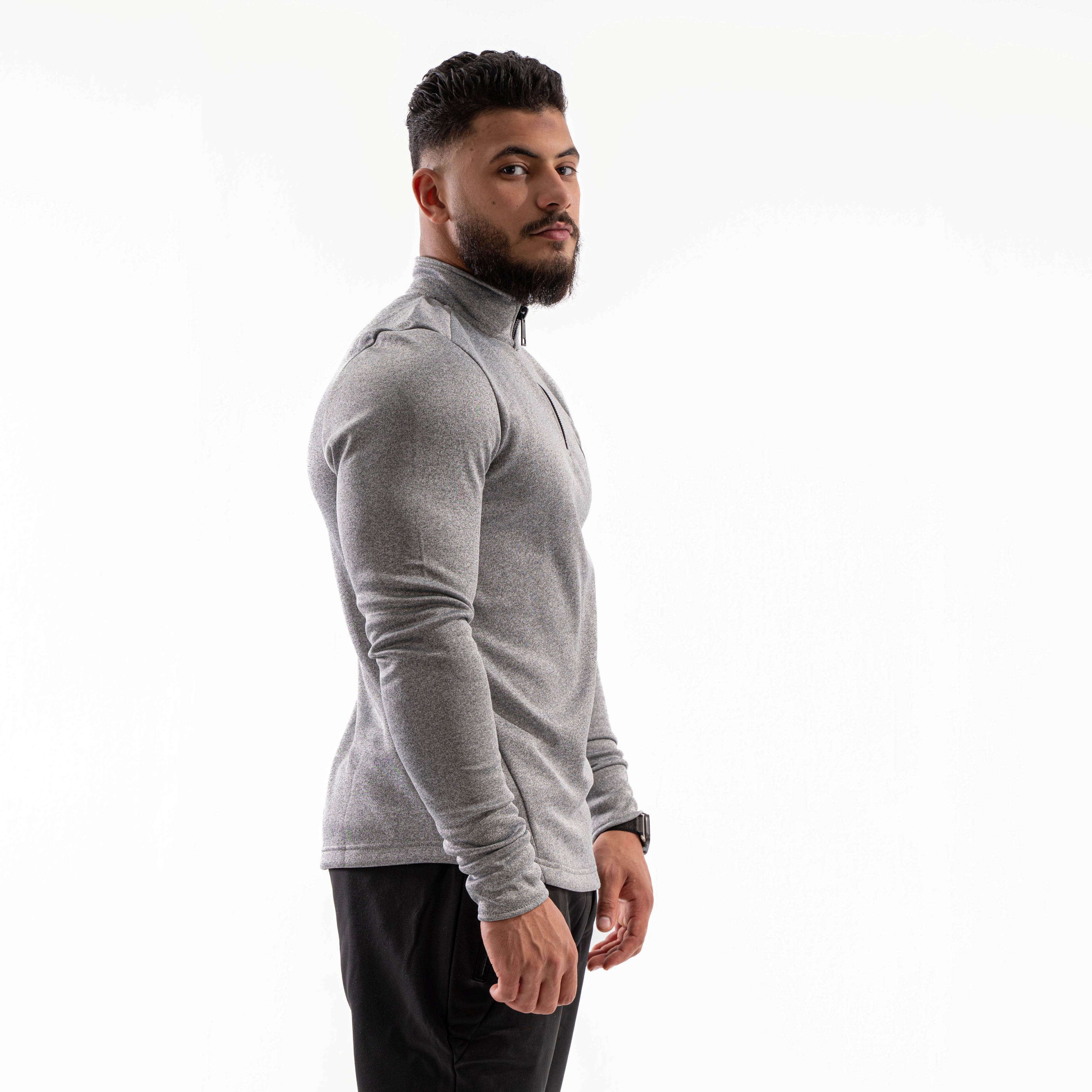 Man wearing a gray long-sleeve athletic shirt on a white background