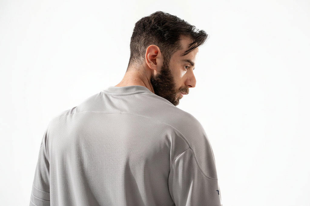Man wearing a gray short-sleeve shirt on a white background