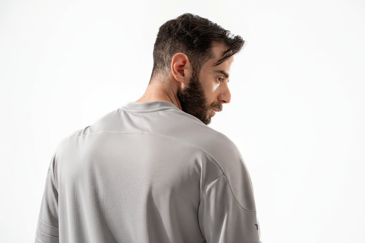Man wearing a gray short-sleeve shirt on a white background