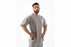 Man wearing a gray sports outfit with visible branding on a white background

