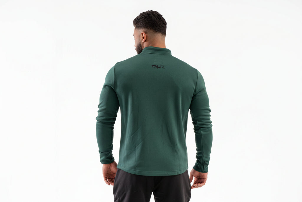 Man wearing a green athletic jacket with a brand logo on the back against a white background
