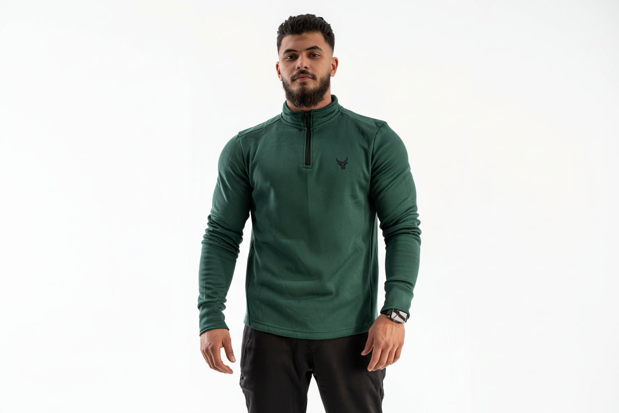 Man wearing a green long-sleeve shirt with a small logo on a white background