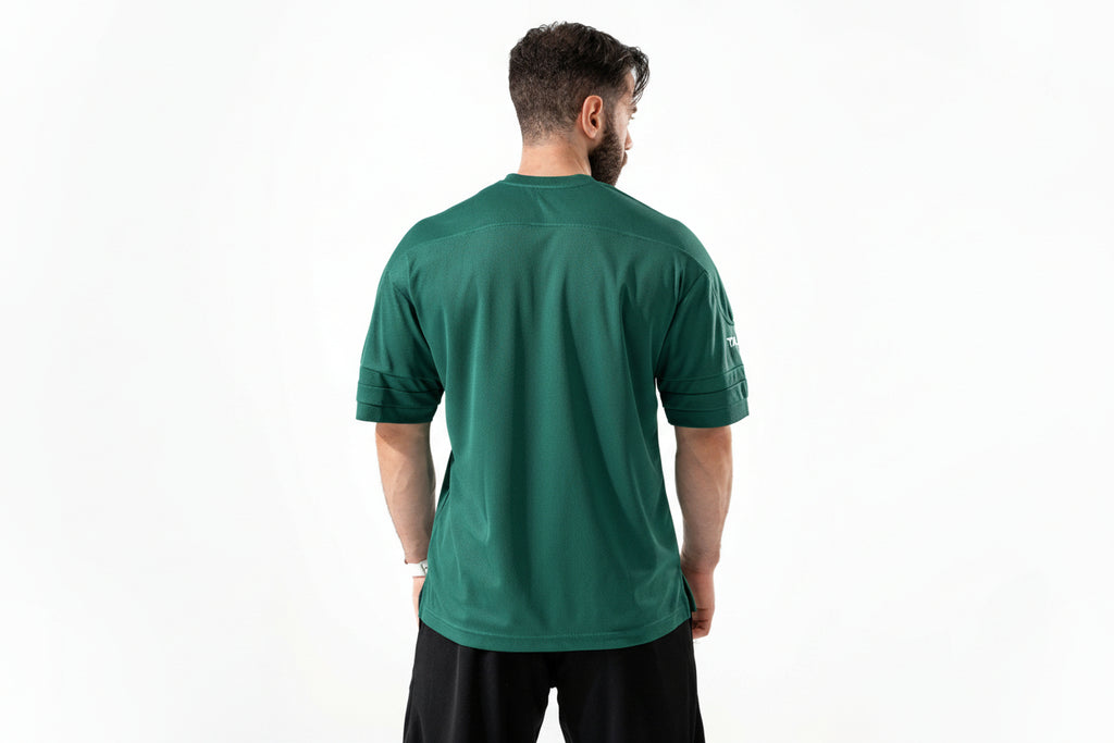 Man wearing a green athletic shirt with a visible brand logo on the back.

