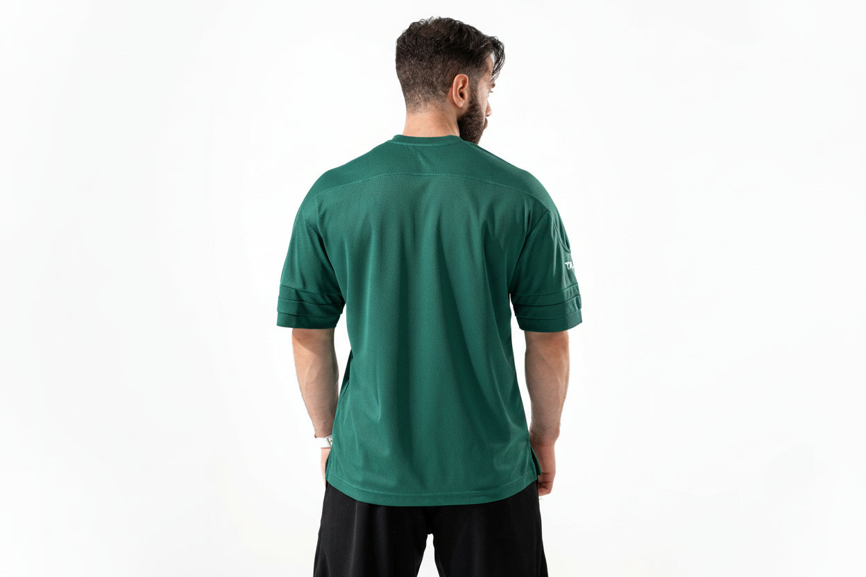 Man wearing a green athletic shirt with a visible brand logo on the back.

