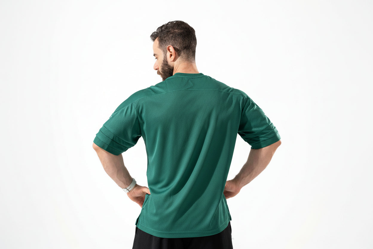 Man wearing a green athletic shirt on a white background

