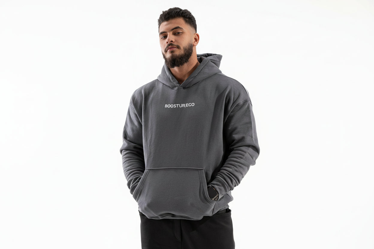 Man wearing a gray hoodie with 'BOSTURECO' logo on a white background

