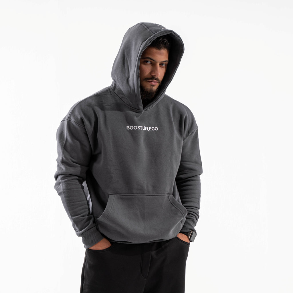 Man wearing a gray hoodie with 'BOOSTUREGO' logo on a white background

