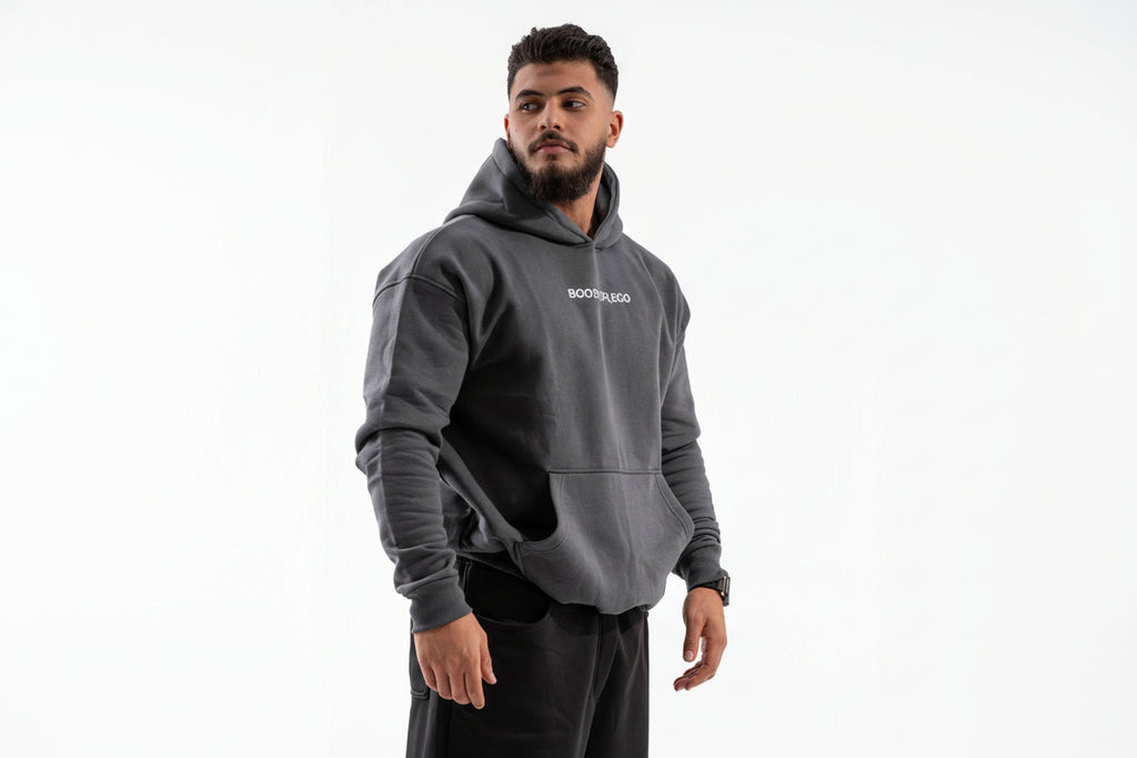 Man wearing a gray hoodie with 'BOSS' branding on a white background

