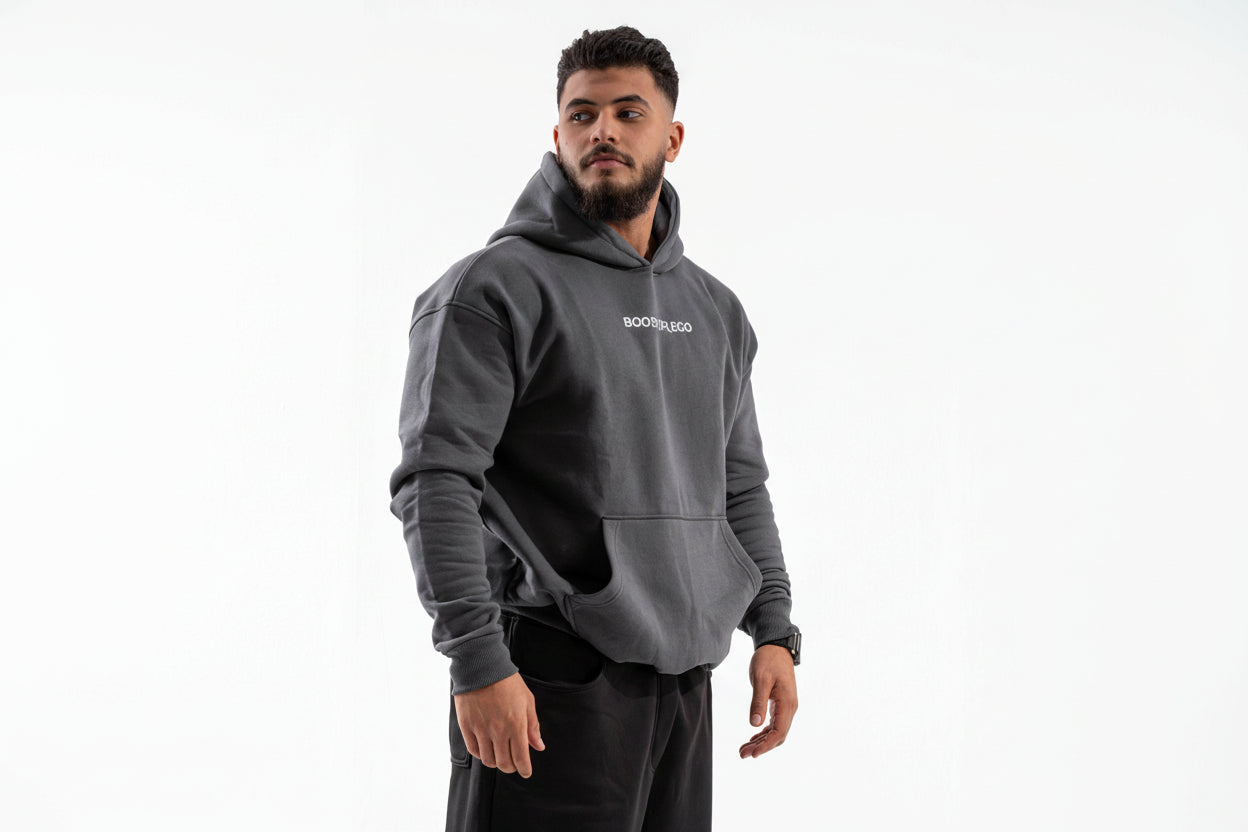 Man wearing a gray hoodie with 'BOSS' branding on a white background

