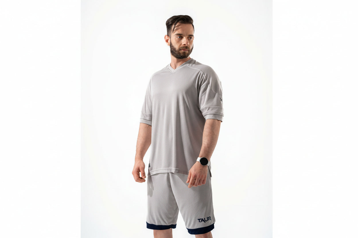 Man wearing a gray athletic outfit with 'Talika' branding on a white background

