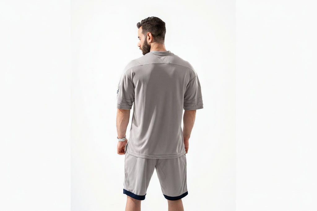 Man wearing a gray athletic outfit on a white background

