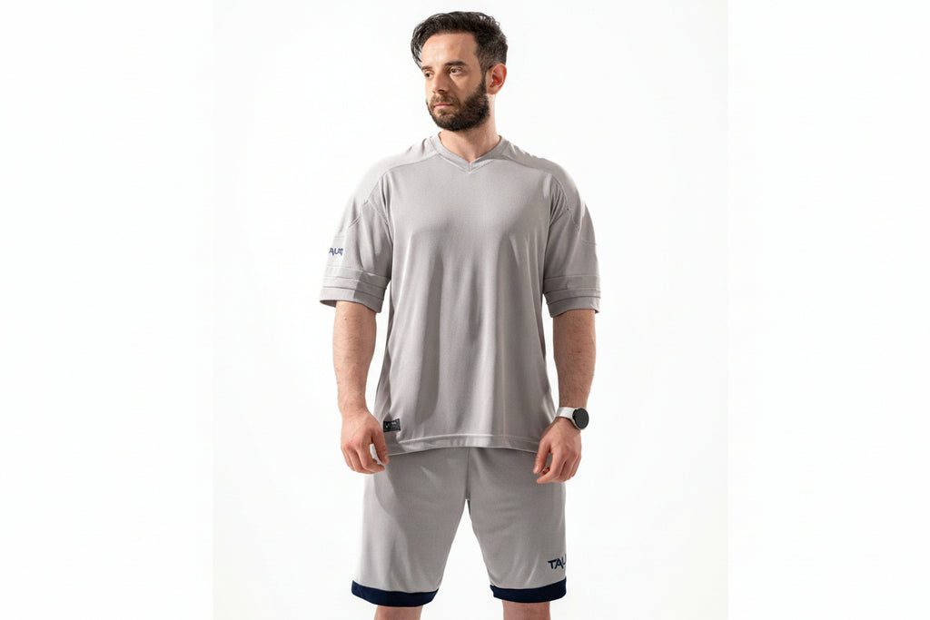 Man wearing a gray athletic outfit with a white background


