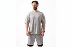 Man wearing a gray athletic outfit with a white background

