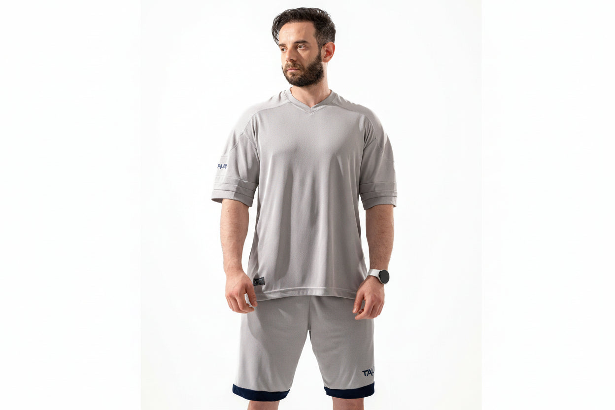 Man wearing a gray athletic outfit with a white background

