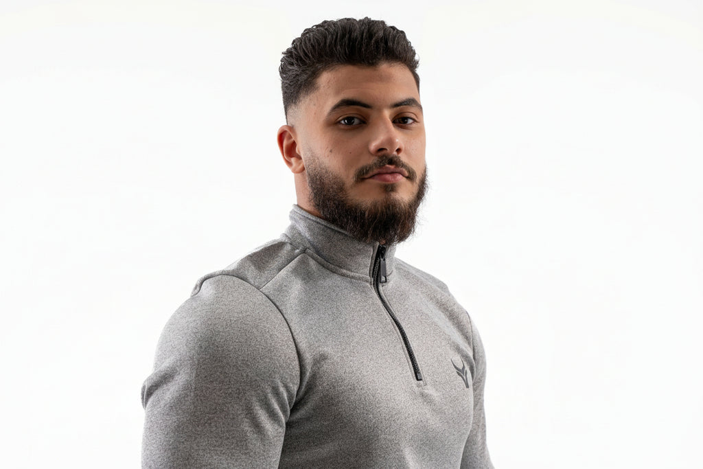 Man wearing a gray athletic jacket on a white background