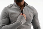 Person wearing a gray quarter-zip sweatshirt with a logo on a white background