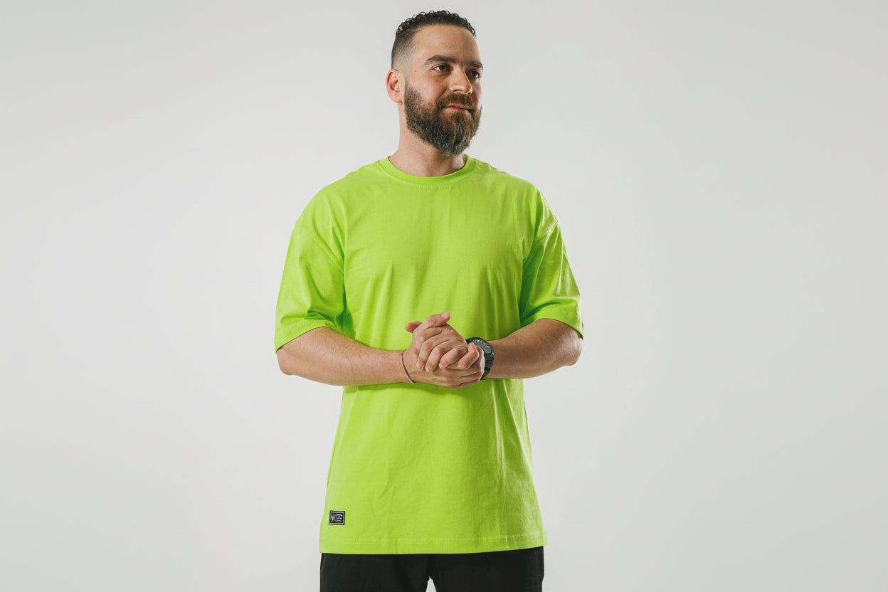 Man wearing a bright green t-shirt against a plain background

