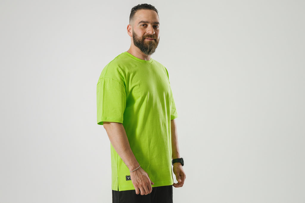 Man wearing a bright green t-shirt against a plain background

