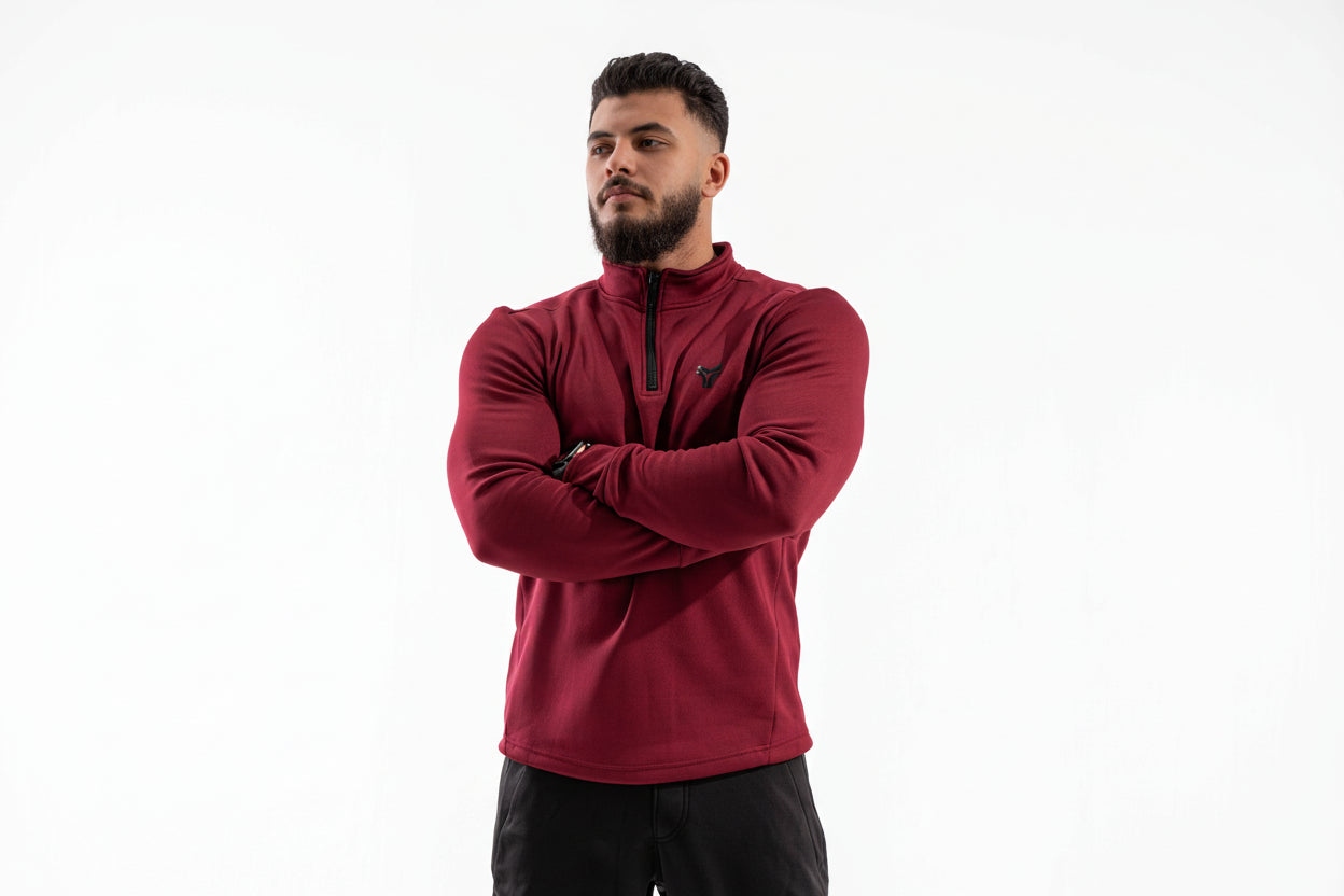 Man wearing a red pullover with a black zipper on a white background